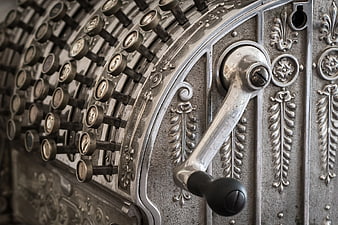 Close-up of vintage cash register with ornate metal details