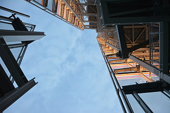 Low angle view of modern steel architecture against blue sky