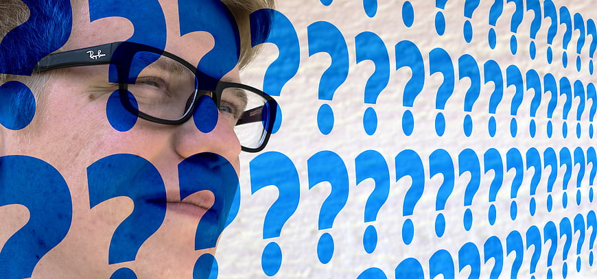Man with glasses and blue question marks conceptual portrait