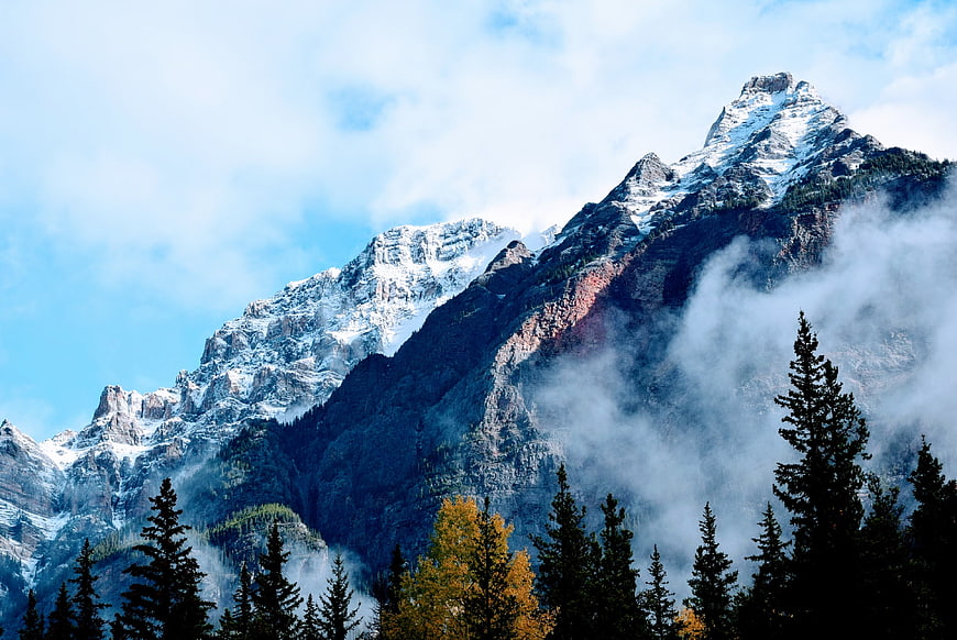 Majestic Snow-Capped Mountain Peak with Misty Forest