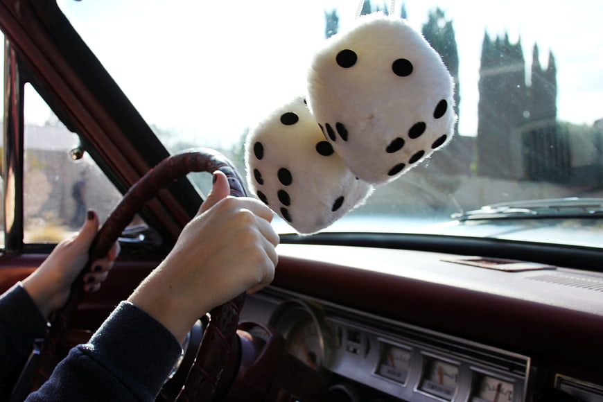 Fuzzy dice hanging in vintage car interior