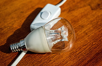 Close-up of a halogen light bulb with switch on wood