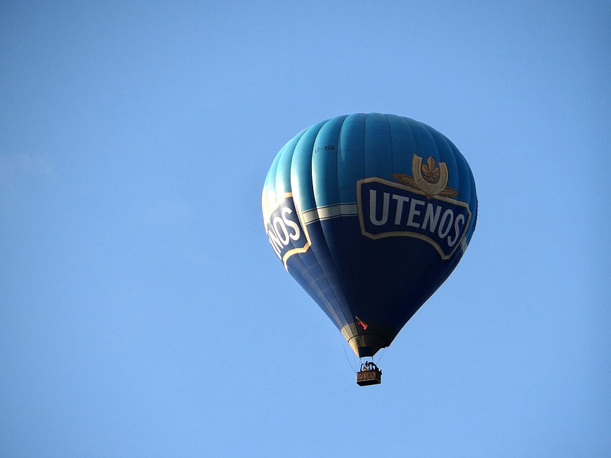 Blue Utenos Hot Air Balloon Floating In Clear Blue Sky
