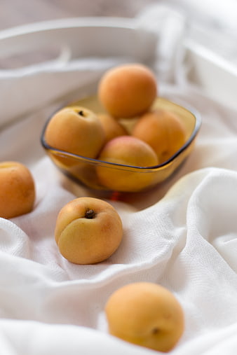 Fresh Apricots in Amber Glass Bowl on White Linen