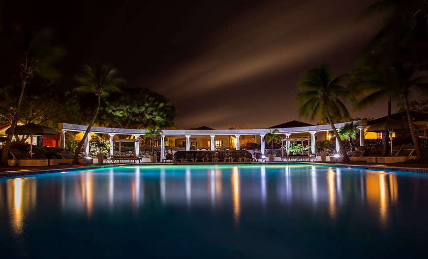 Luxury Resort Pool at Night with Palm Trees and Reflections