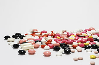 Assorted colorful pills and capsules on white background