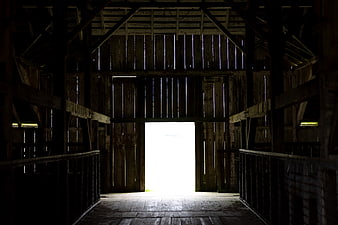 Dark rustic barn interior with bright open doorway