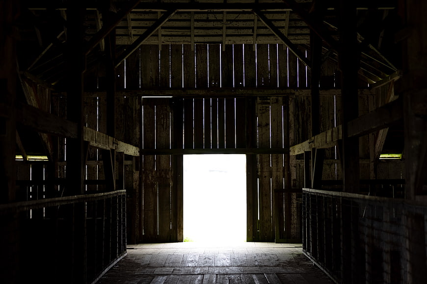 Dark rustic barn interior with bright open doorway