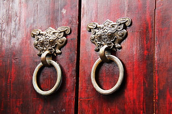 Traditional Chinese Bronze Door Knocker on Red Wooden Door