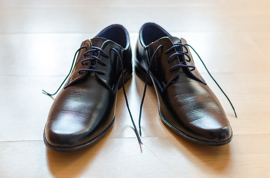 Shiny Black Leather Dress Shoes on Wooden Floor