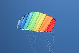 Colorful Rainbow Kite Flying Against Clear Blue Sky