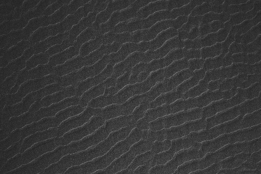 Dark textured sand ripples pattern background