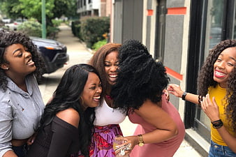 Group of laughing women friends on city street