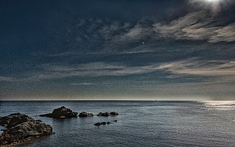 Dramatic Ocean Seascape with Rocky Shore and Cloudy Sky