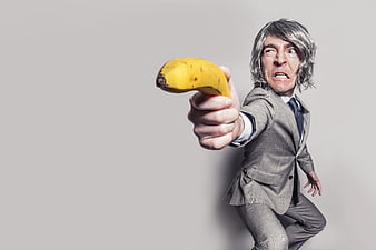 Man in Suit Pointing Banana Like a Gun