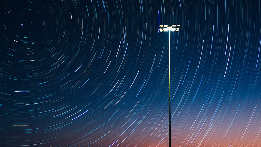 Star trails circling a stadium light pole at night
