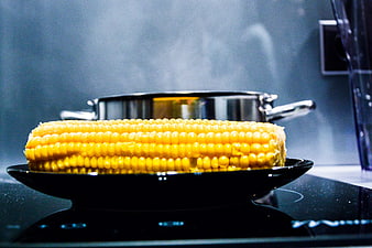 Steaming Corn on the Cob on Black Plate in Kitchen