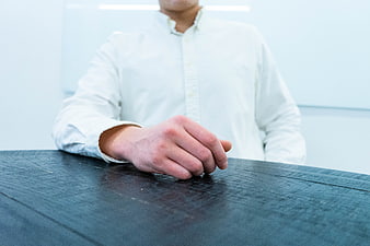 Close-up of man's hand on dark wooden table in office