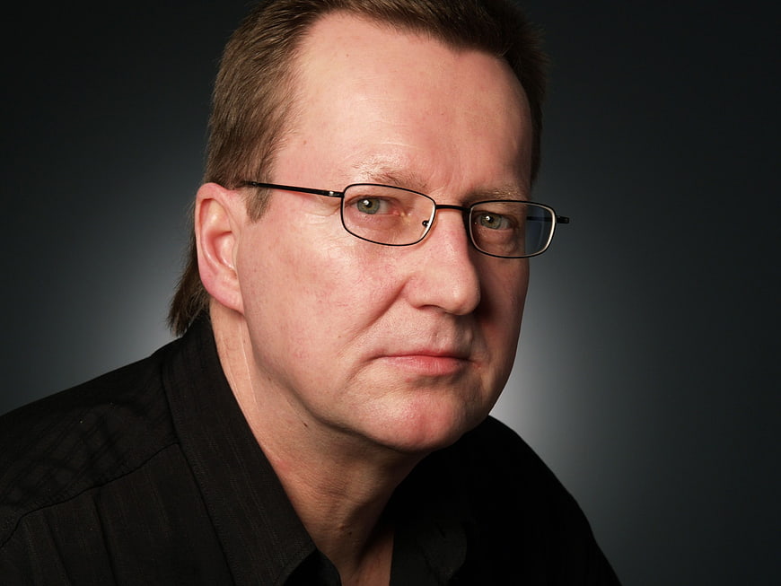 Portrait of a serious man with glasses and black shirt