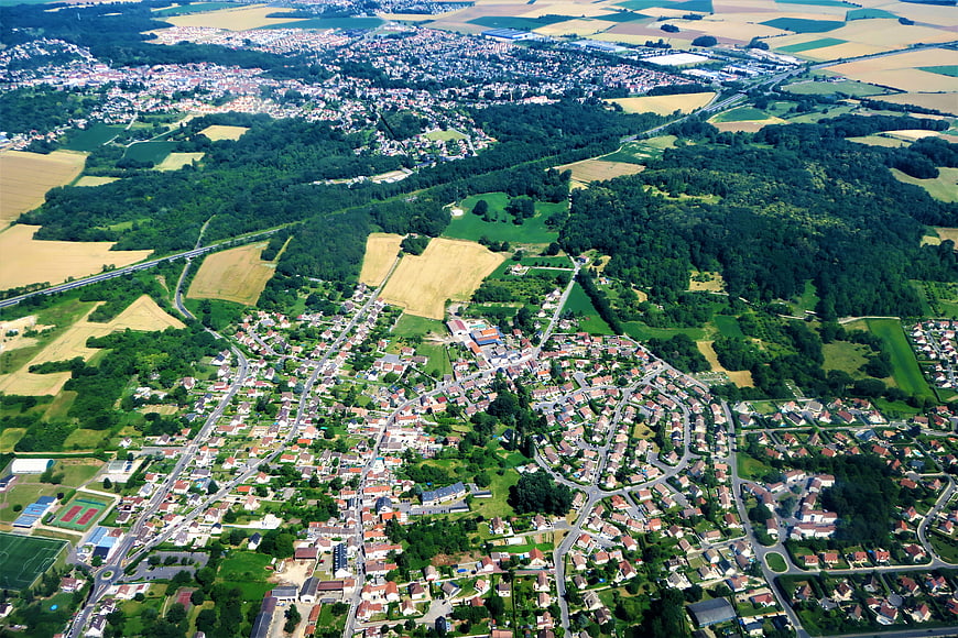 Aerial view of suburban town surrounded by green fields and forests