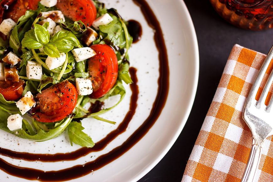 Fresh Caprese Salad With Basil And Balsamic Glaze On White Plate