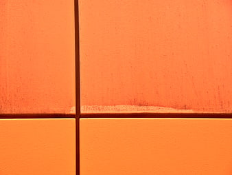 Close-up of textured orange wall tiles with grout lines