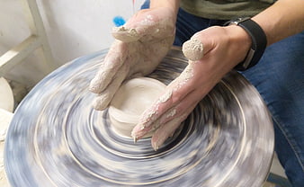 Close-up of hands shaping clay on a spinning pottery wheel