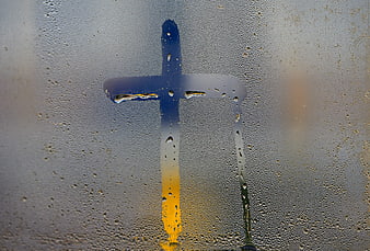 Christian Cross Silhouette Behind Condensed Rainy Window Pane