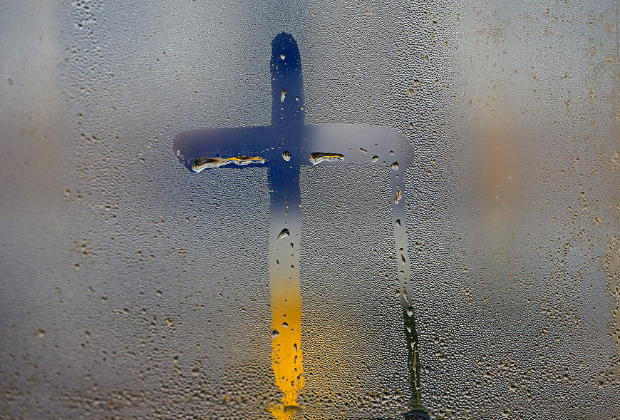 Christian Cross Silhouette Behind Condensed Rainy Window Pane