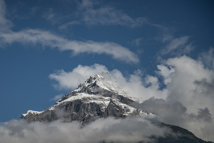 Snowy Mountain Peak Emerging from Clouds