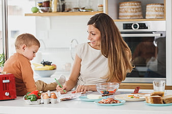 Mother and son cooking together in a bright modern kitchen