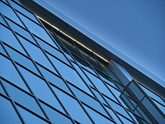 Modern Glass Building Facade with Blue Sky Reflection
