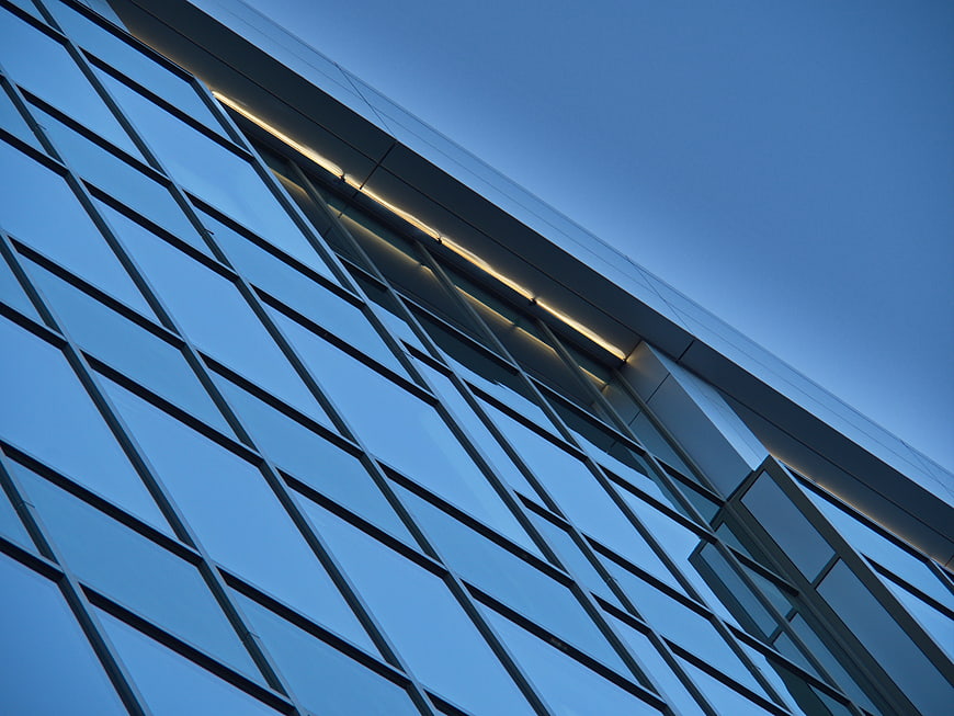 Modern Glass Building Facade with Blue Sky Reflection