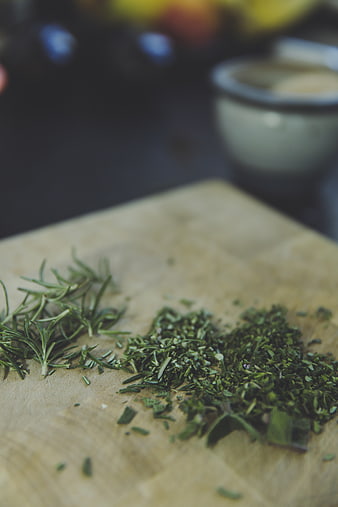 Fresh and Chopped Rosemary Herbs on Wooden Cutting Board