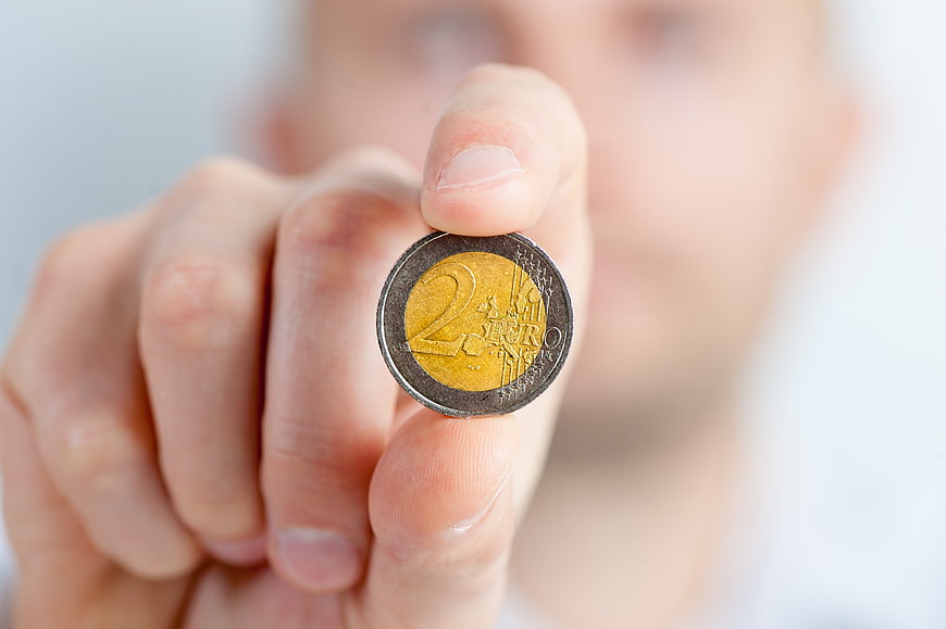 Hand holding two euro coin close up
