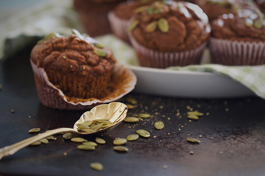 Homemade pumpkin muffins with seeds on dark rustic table