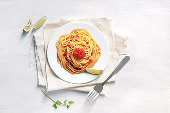 Top View Spaghetti with Tomato Sauce and Lime on White Plate