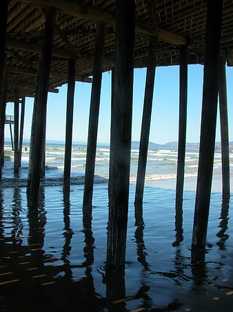 View Under Wooden Pier at Beach with Ocean Waves