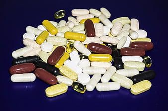 Assorted Vitamins and Supplements on Dark Blue Background