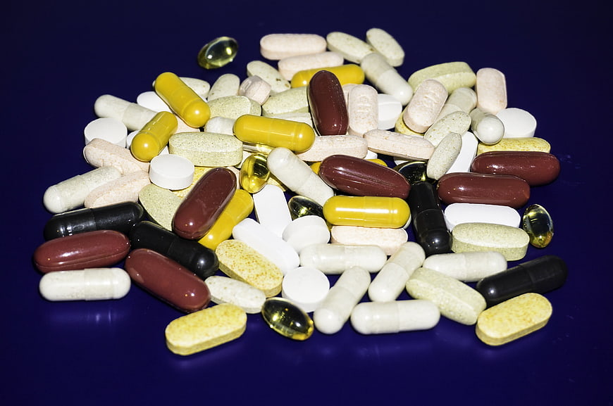 Assorted Vitamins and Supplements on Dark Blue Background