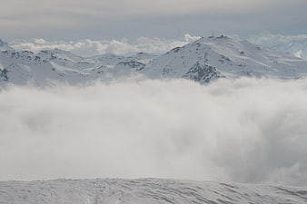 Snowy mountain peaks rising above a thick sea of clouds