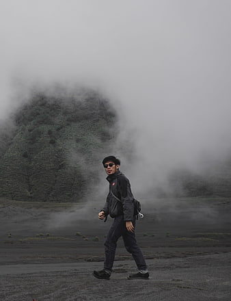 Man hiking in foggy volcanic landscape at Mount Bromo