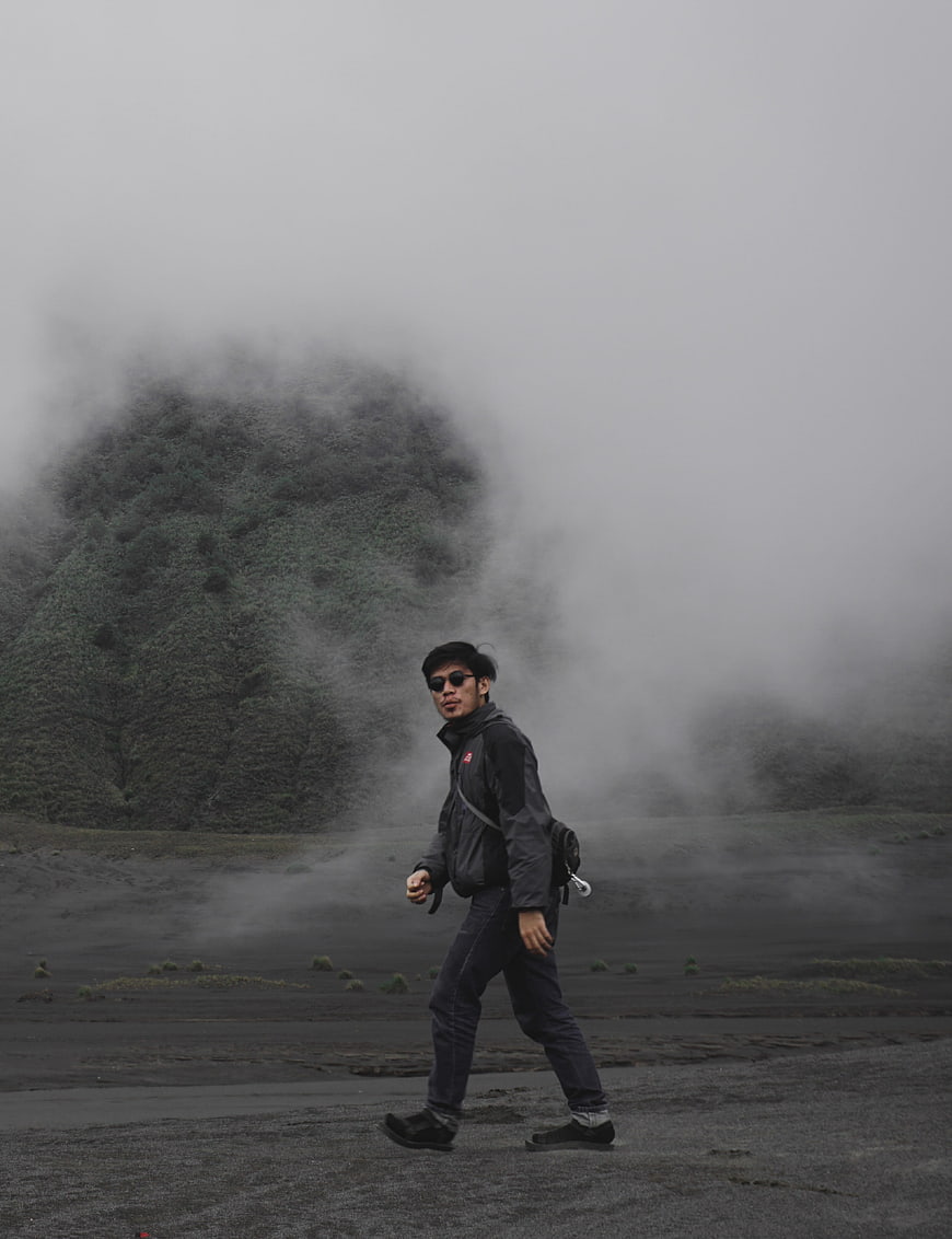 Man hiking in foggy volcanic landscape at Mount Bromo