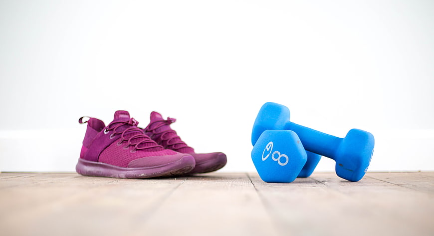 Purple Sneakers and Blue Dumbbells on Wooden Floor