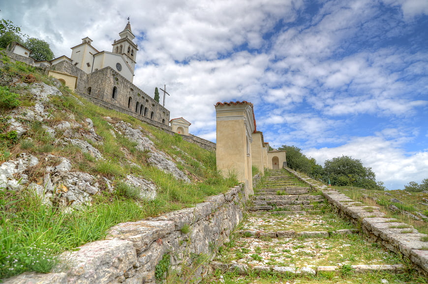 Stone staircase leading to historic church on grassy hill