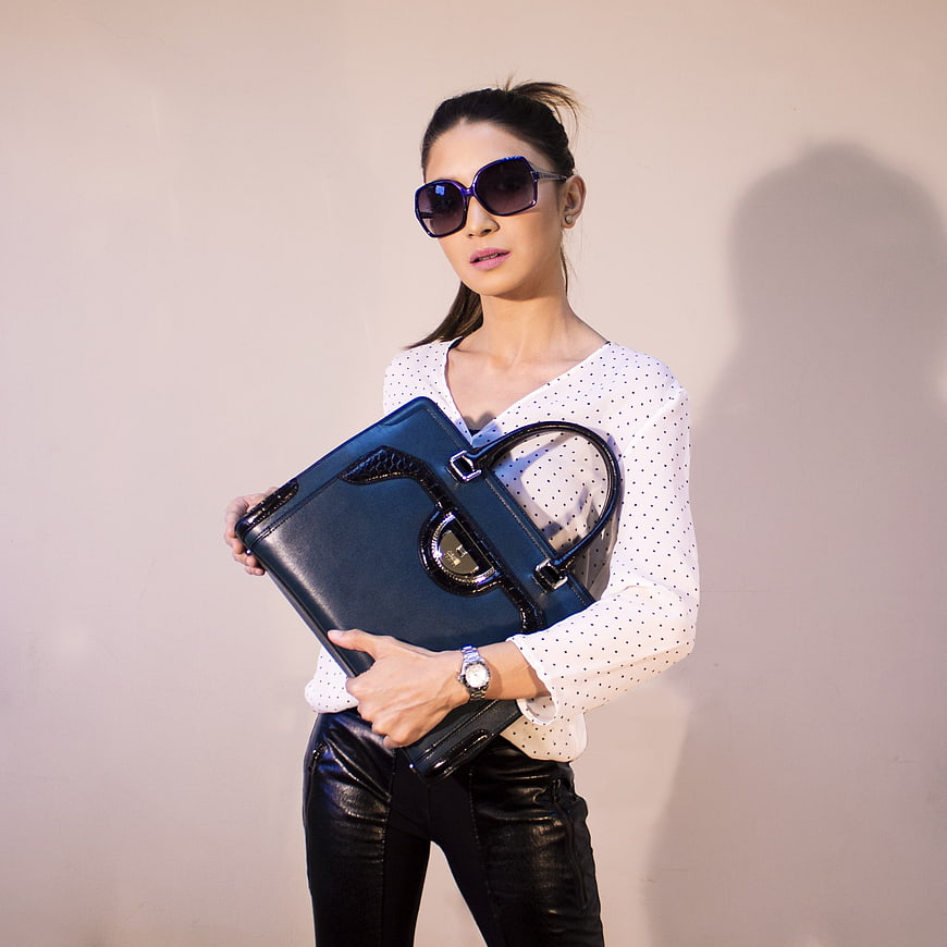 Stylish Woman Holding Black Leather Handbag and Wearing Sunglasses