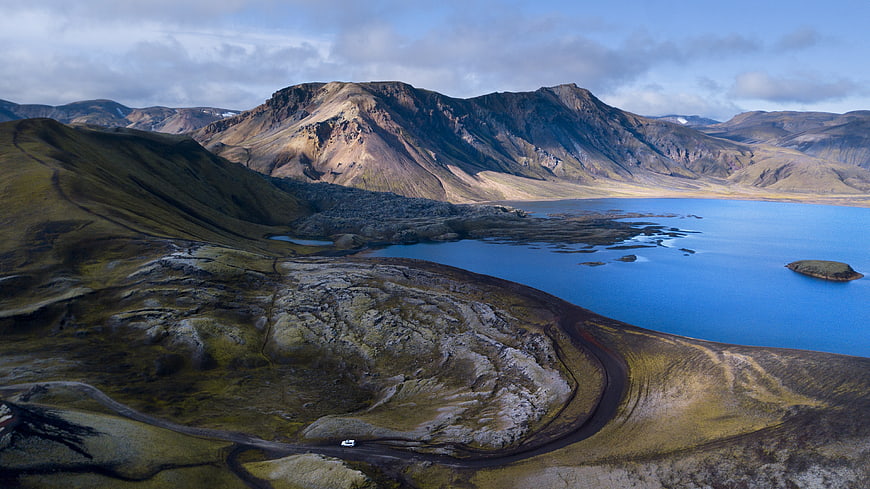 Aerial view of winding road near blue lake in Iceland mountains