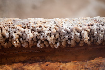 Close-up of crystallized salt deposits on a rusty metal surface