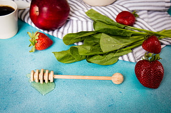 Healthy breakfast ingredients with honey dipper on blue background
