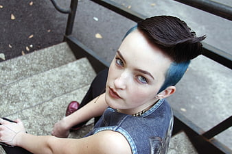 Portrait of woman with blue undercut hair on stairs